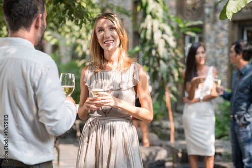 Pretty woman talking with male guest at the party photo