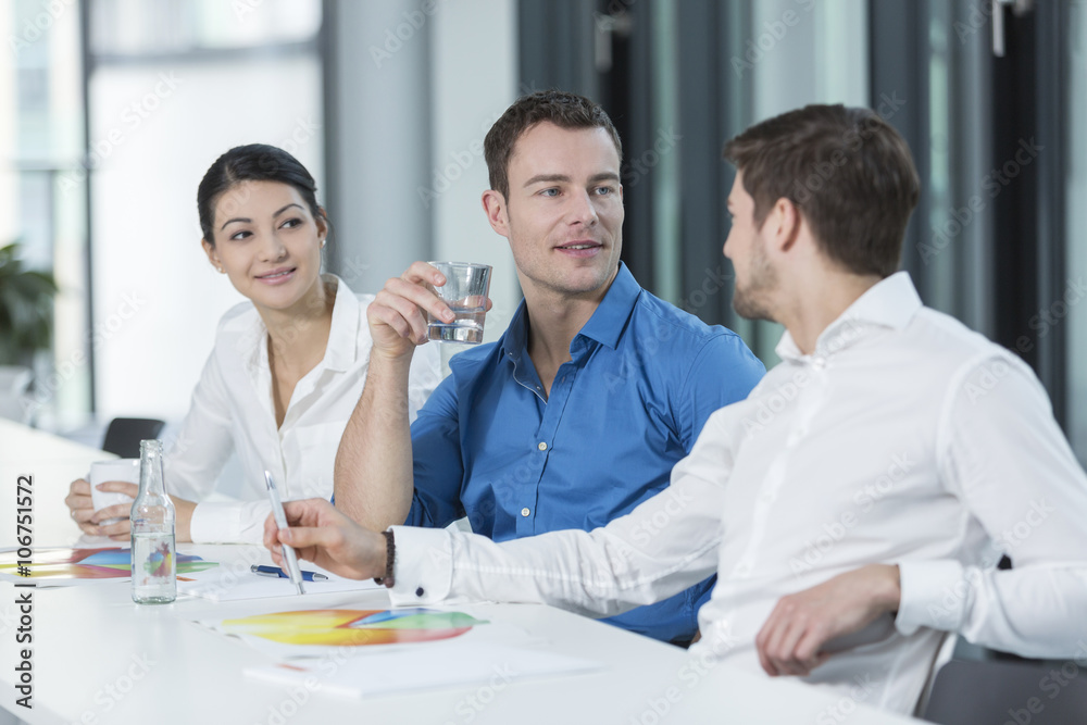 Three business people in a conference room Three business people in a conference room