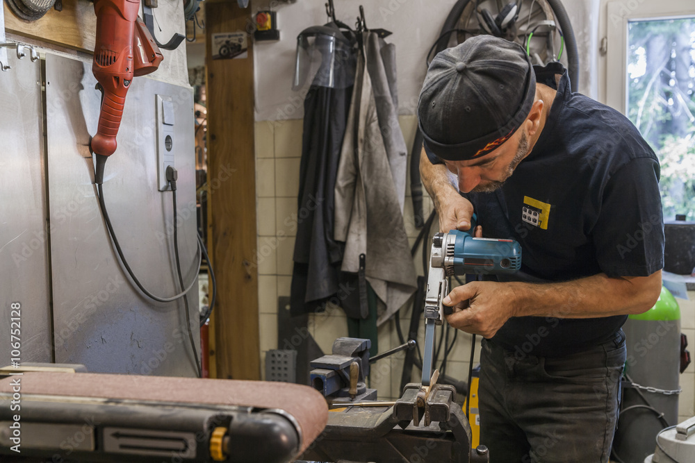 Knife maker in workshop at work Knife maker in workshop at work