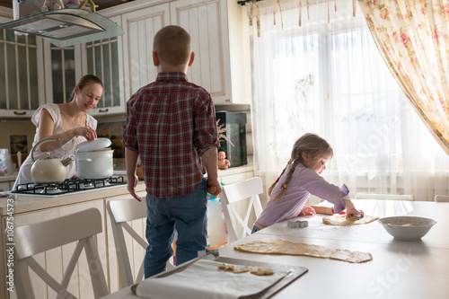 Mother with three kids cooking biscuits casual lifestyle photo