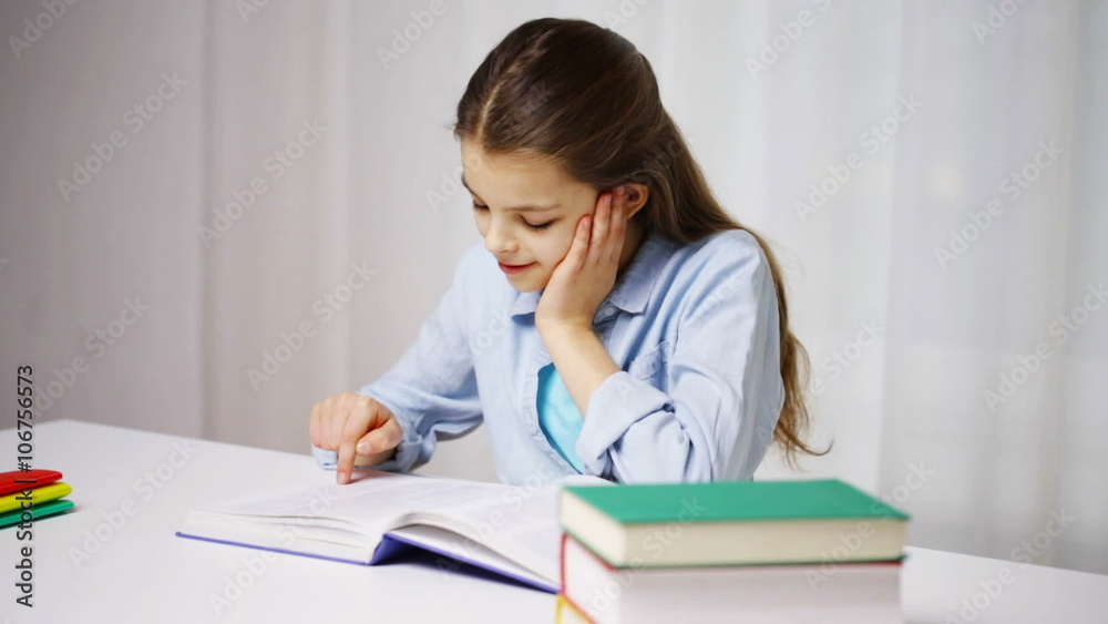 happy school girl reading book or textbook at home happy school girl reading book or textbook at home
