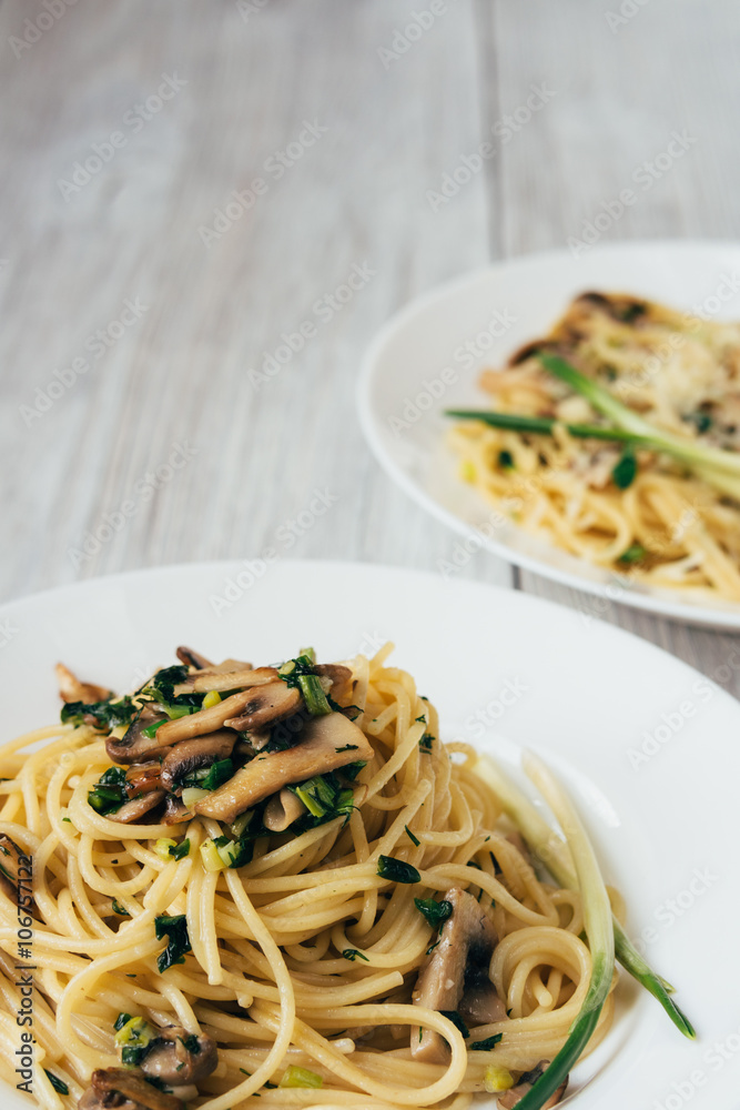 Spaghetti with mushrooms on a wooden table