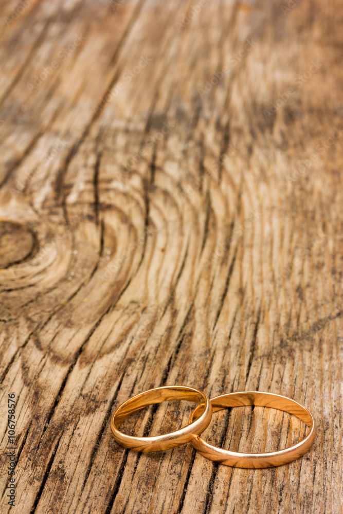 male and female wedding rings of gold on an old cracked wooden board. selective focus. Free space for text. Copy space male and female wedding rings of gold on an old cracked wooden board. selective focus. Free space for text. Copy space