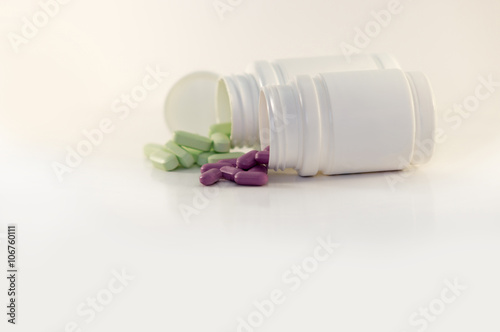 Vitamin tablets scattered on a white background