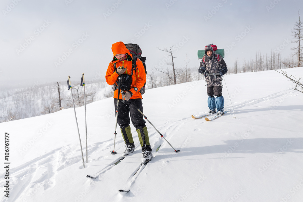 High altitude view of two skiers walking on a mountain ridge in High altitude view of two skiers walking on a mountain ridge in