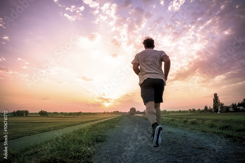 Rear view of man jogging at sunset