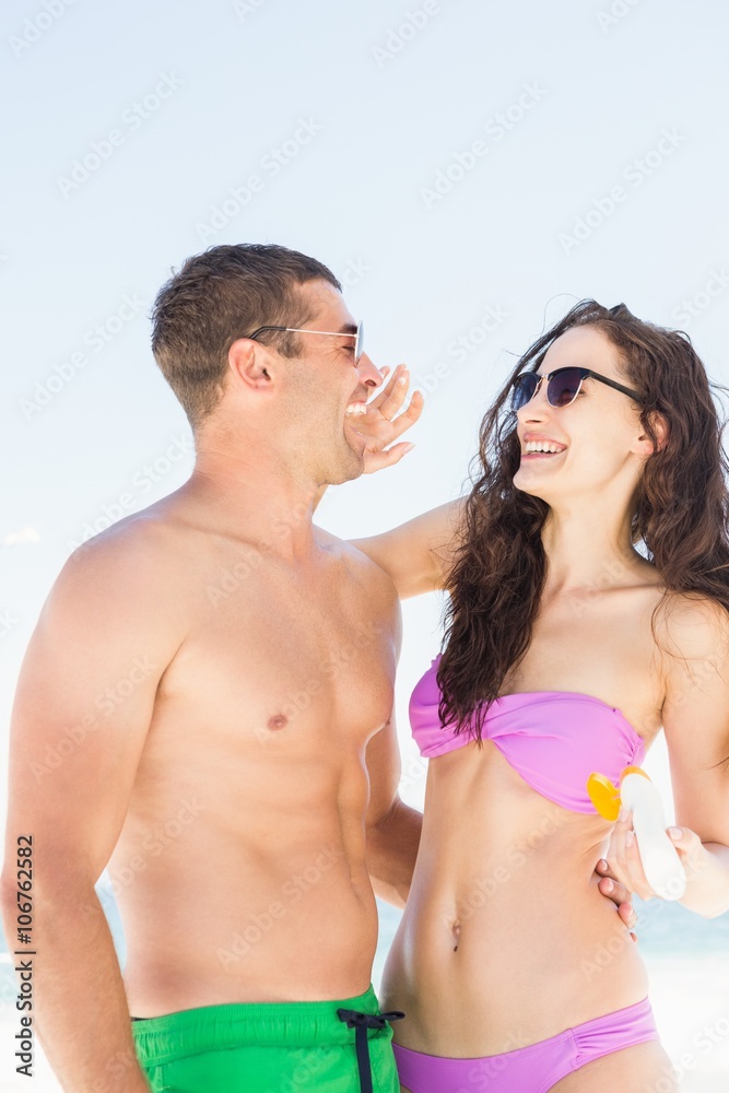Girlfriend applying sun cream on boyfriend Girlfriend applying sun cream on boyfriend