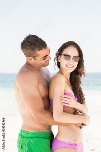 Smiling couple hugging on the beach