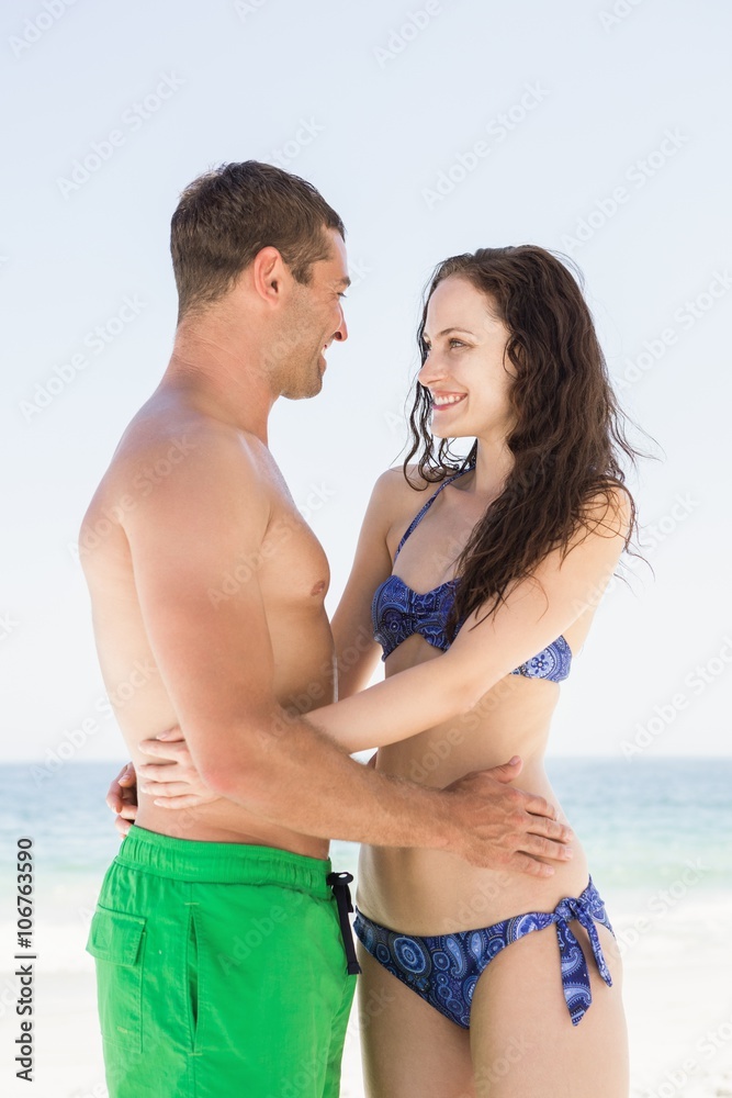 Smiling couple embracing on the beach Smiling couple embracing on the beach