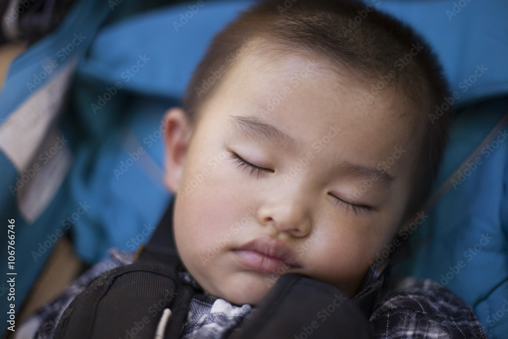 Cute Chinese baby boy in sleep in a baby stroller Cute Chinese baby boy in sleep in a baby stroller