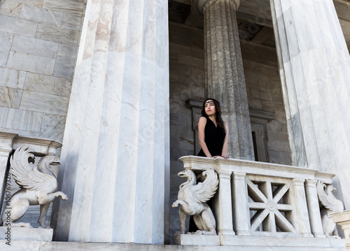 Fototapete young lady in black dress on stone balcony