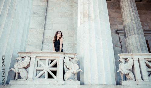 Foto young lady in black dress on stone balcony
