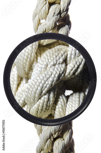 braided rope under a magnifying glass on a white background / плетеный канат под лупой на белом фоне