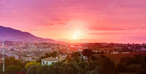 Sunset Over Mountains And Spanish Town. Cityscape. Panorama.