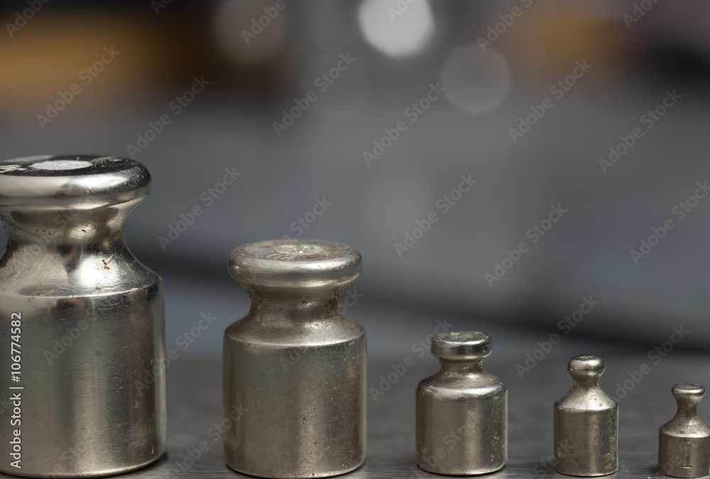 Plummets set on weigh-scales. Jewelry workplace on metal background with copy space for text. Plummets set on weigh-scales. Jewelry workplace on metal background with copy space for text.