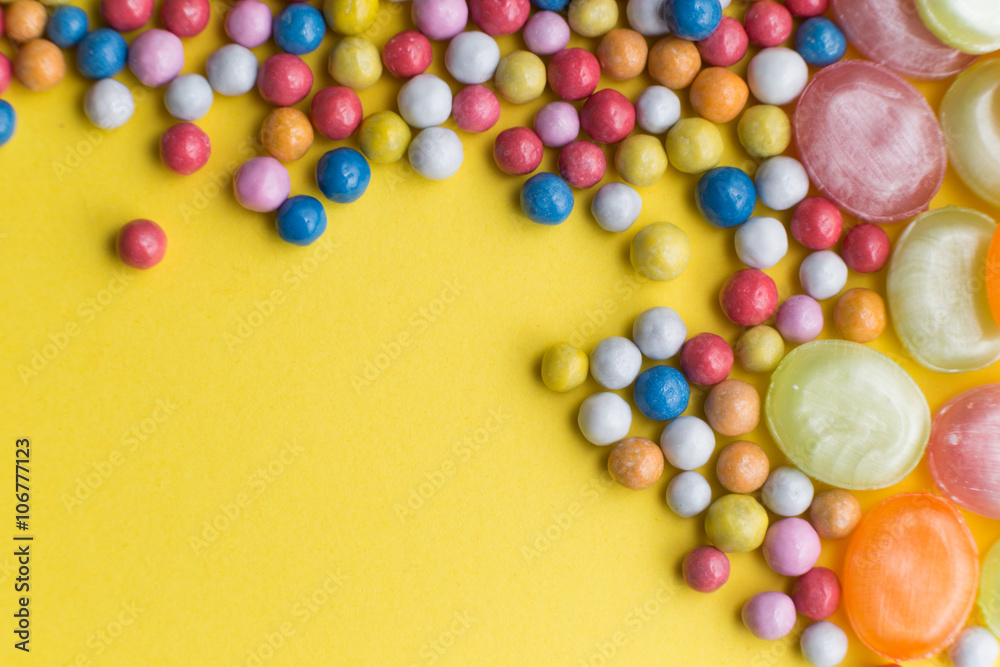 Obraz premium Candies colorful mix on yellow bright background with copy space