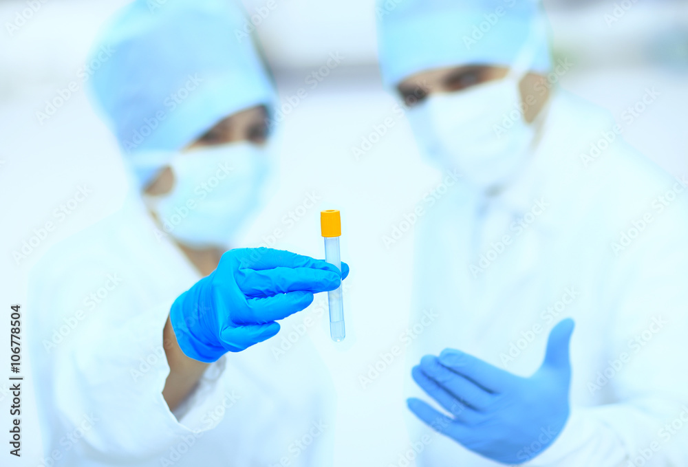 Two chemists are analyzing a liquid mixture in a test tube.