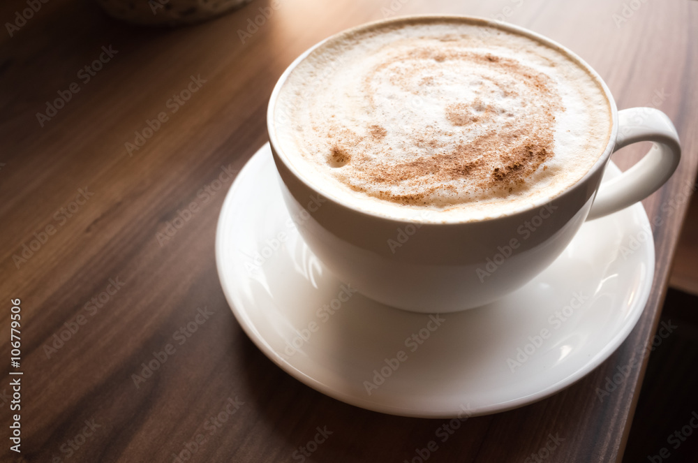 Cup of cappuccino on wooden table in cafeteria Cup of cappuccino on wooden table in cafeteria