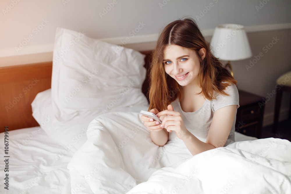 Smiling girl look to camera while browsing web on cellphone Smiling girl look to camera while browsing web on cellphone