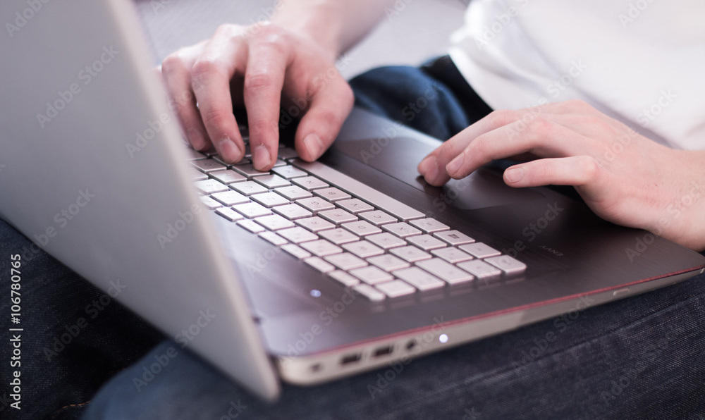 Laptop am Schoß, Tastatur und Männerhände