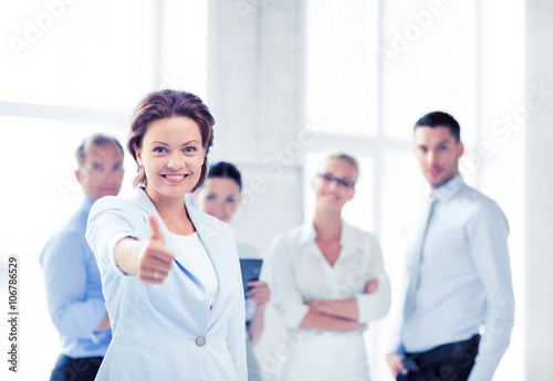 businesswoman in office showing thumbs up