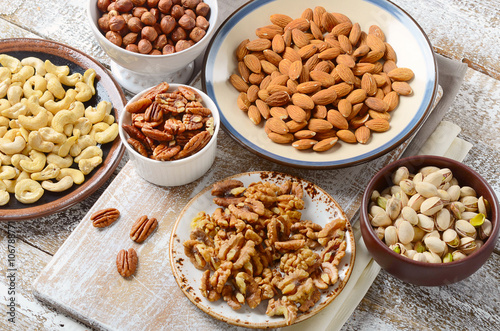Assorted mixed nuts on wooden board.