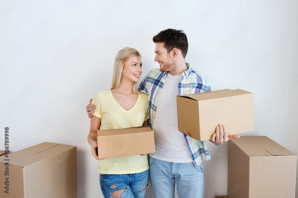 smiling couple with big boxes moving to new home smiling couple with big boxes moving to new home