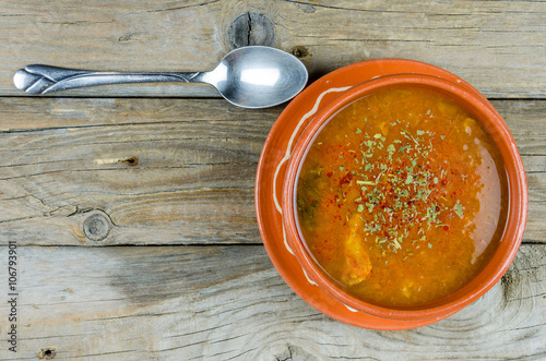 fish soup into a clay plate at board or table photo