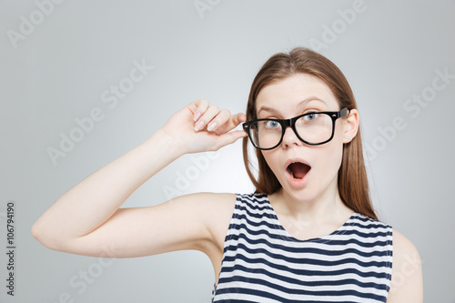 Amazed charming teenage girl in glasses with mouth opened over