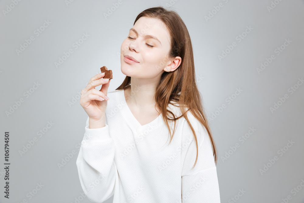 Lovely smiling teenage girl with eyes closed eating chocolate Lovely smiling teenage girl with eyes closed eating chocolate
