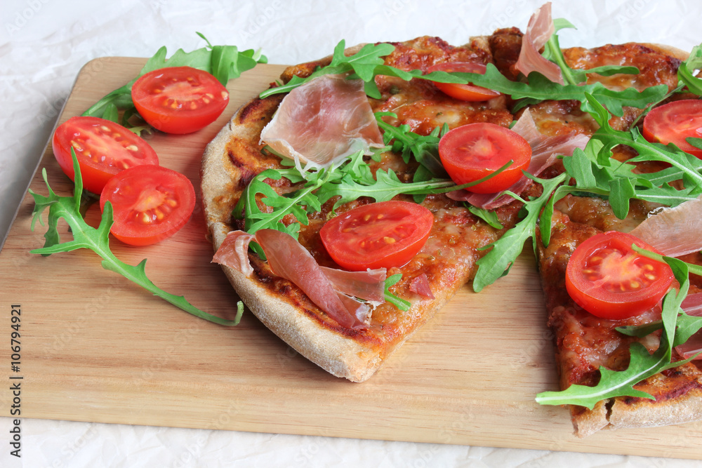 Pizza with Porsciutto, cherry tomatoes and rocket salad