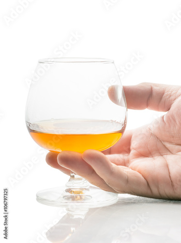 a glass of brandy in hand on a white background.
