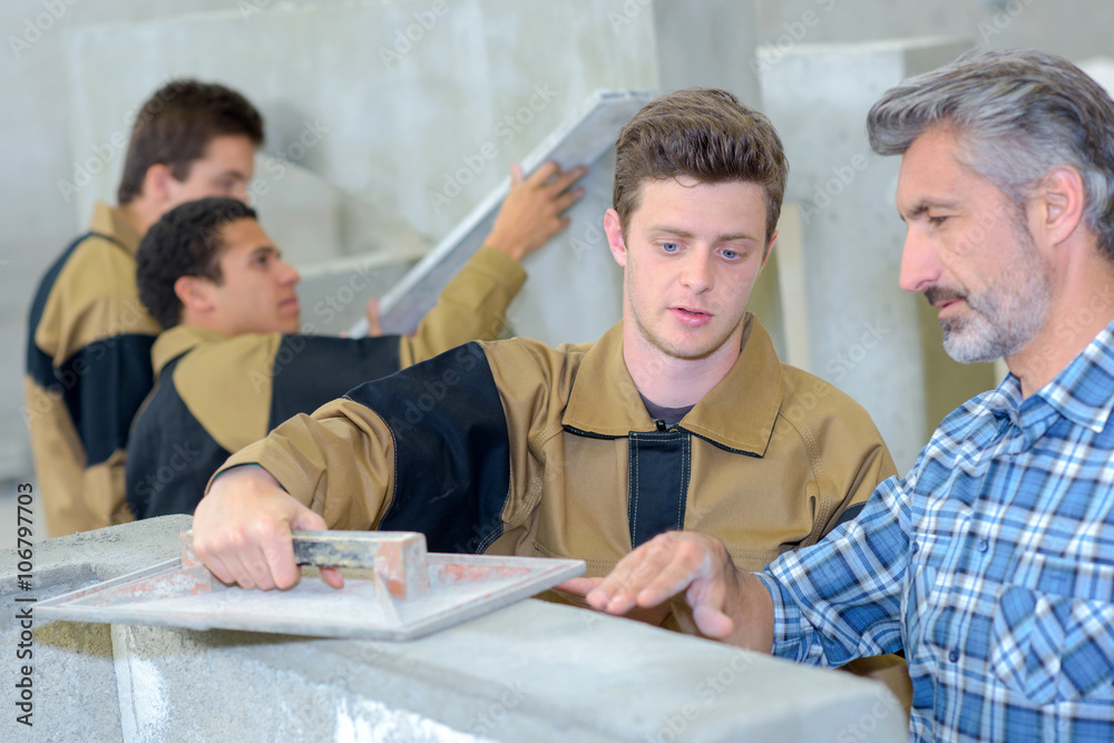 Teacher showing apprentice how to float cement Teacher showing apprentice how to float cement