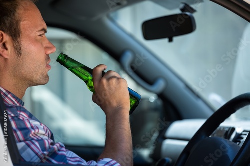 Man drinking beer while driving photo