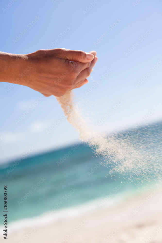 mains qui versent du sable à la plage