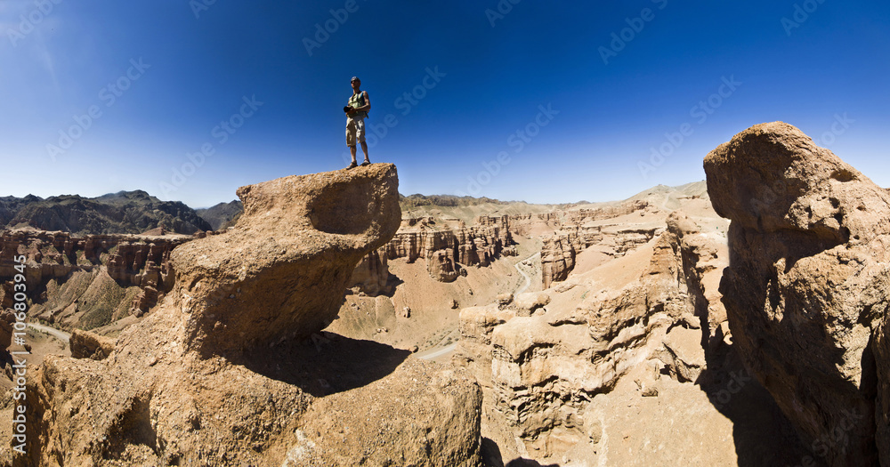 man on a cliff in desert canyon