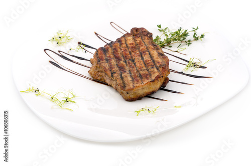 veal steak on a white plate on a white background.