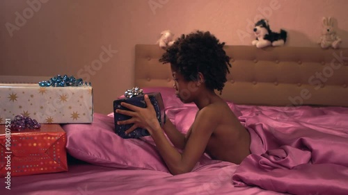 Dark-skinned little boy rejoices of gifts.