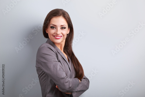 Beautiful business woman in suit smiling on blue background with