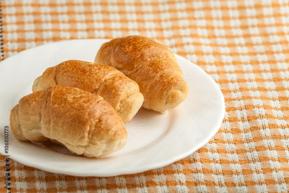 small croissant on wooden background