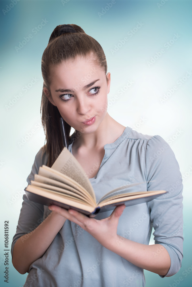 Young beautiful girl reading a book and thinking Young beautiful girl reading a book and thinking