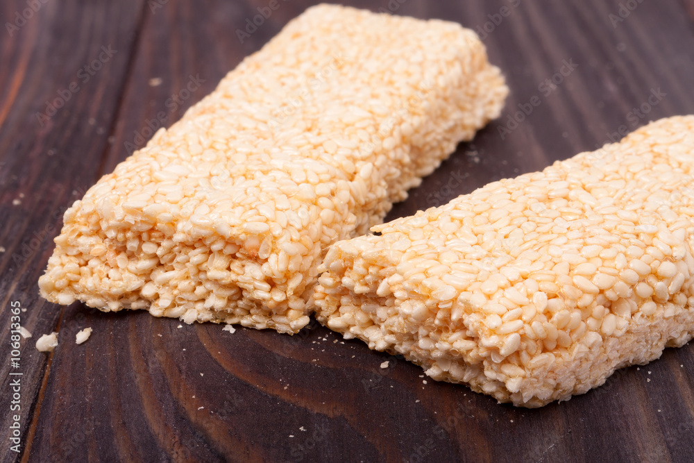 Honey bars with sesame seeds on wooden background