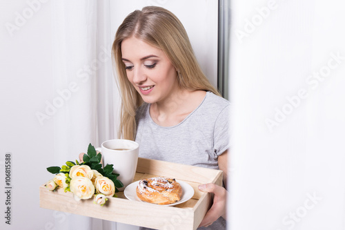 woman holding tray with her breakfast at home