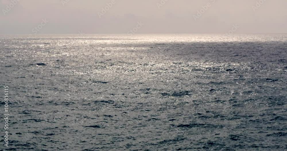 cheggie di sole riflesse sul mare mosso al mattino presto