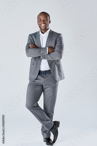 Confident friendly business man smiling in studio full length