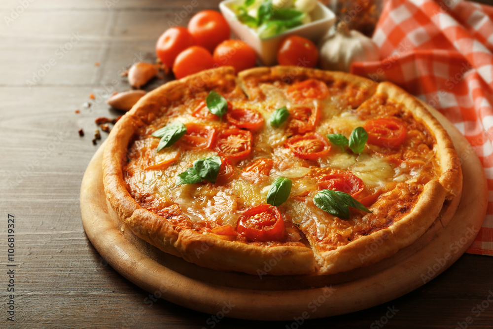 Margherita pizza with spices and tomatoes on wooden background