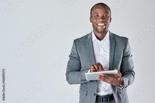 Young black male professional holding tablet device smiling photo