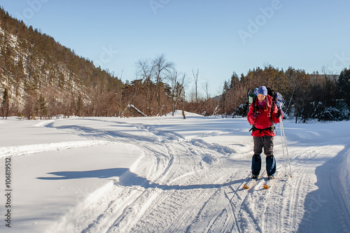 girl skiing on a winter walk with a phone in his hand