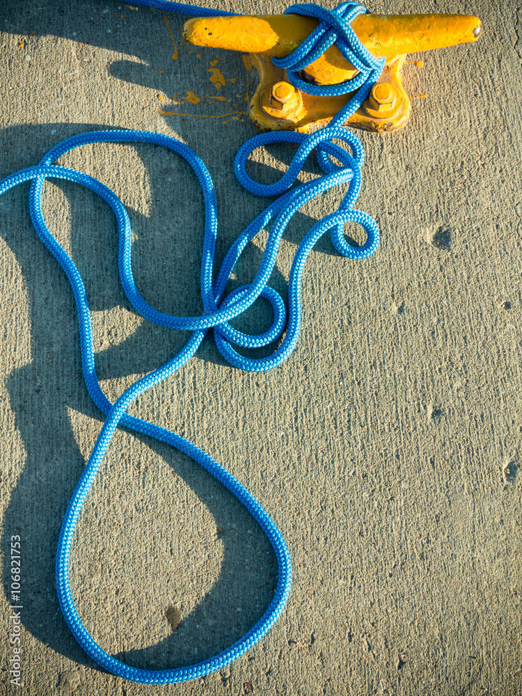 Obraz premium Mooring bollard with rope on pier by the sea