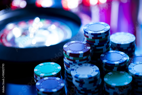 casino theme, high contrast image of casino roulette, playing chips and dice